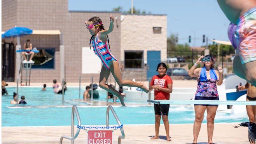 Young swimmer jumping off diving board