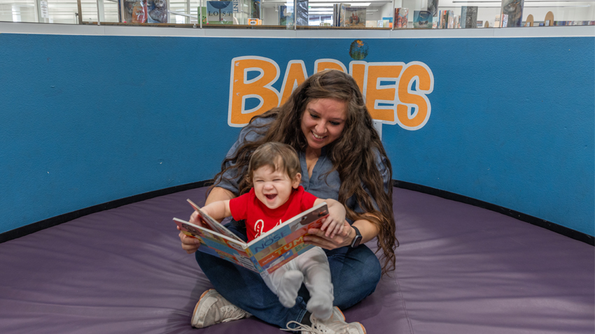 Reading a book with an infant at the Library