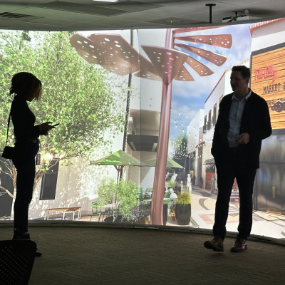 Attendee in front of large screen at immersion lab with consultant