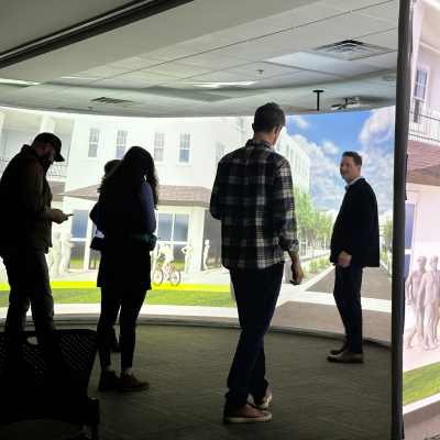 Small group of people in front of large screen at immersion lab