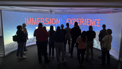 Group of people in front of large screen for immersion lab