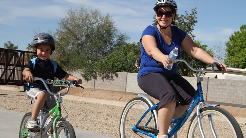 Mother and child riding bikes along Paseo Trail