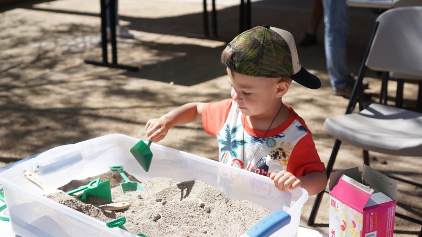 young kid playing in a sandbox