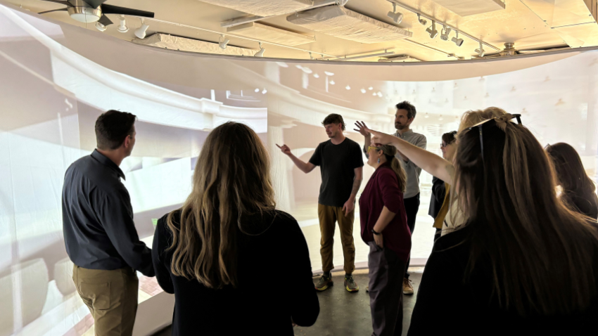 Attendees in front of augmented reality screen