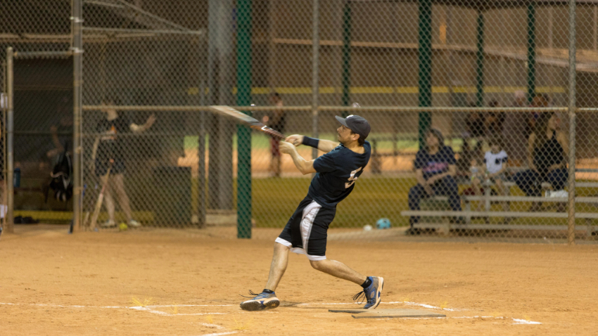 man hitting a softball