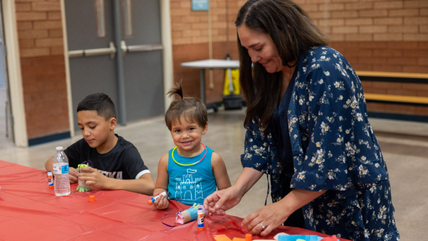 two kids and an adult making crafts