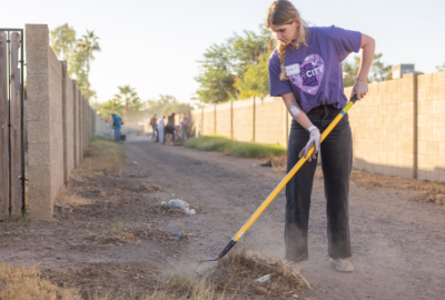 Female volunteer cleaning up an alley