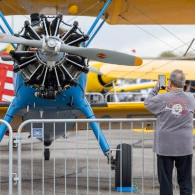 older man taking a photo of an aircraft on display