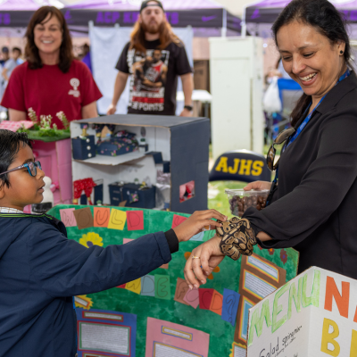 Kid touches a snake during the Chandler Innovation Fair