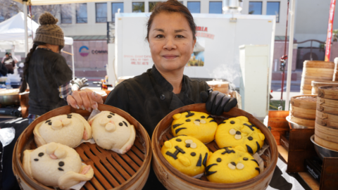 Vendor from last year's Multicultural Festival holding up two dishes