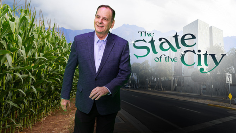 Mayor Hartke stands between a cornfield and Chandler City Hall with the text "The State of the City"