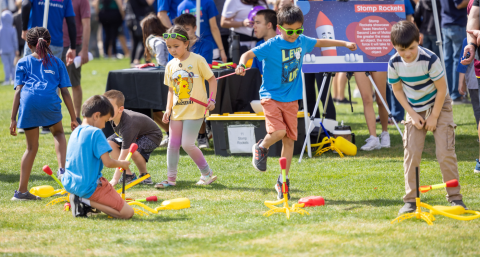 Photo of kids jumping on rocket launchers at the Northrop Grumman booth