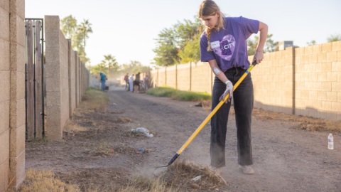 Female volunteer cleaning up an alley